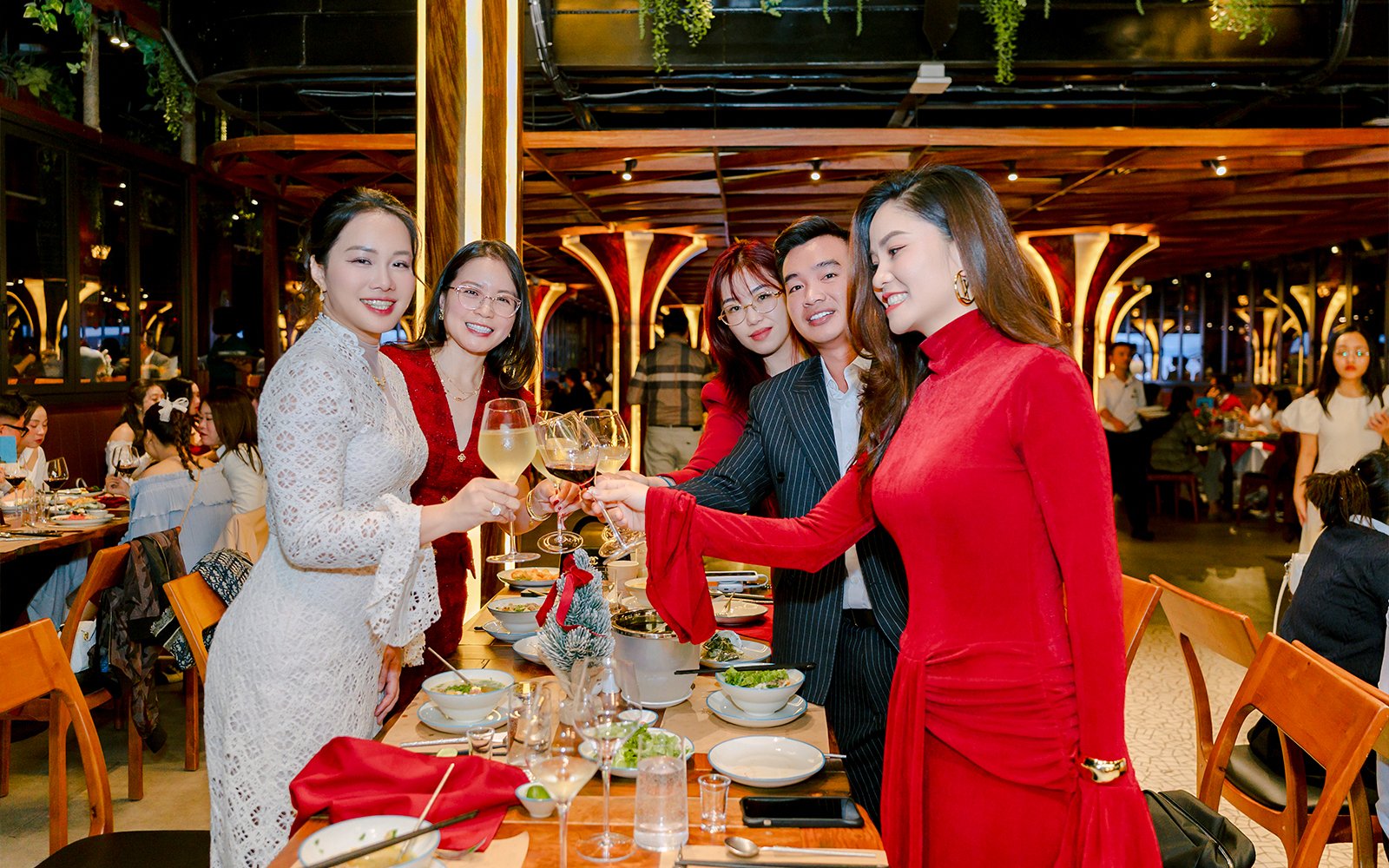 Group enjoying dinner buffet with wine at a festive restaurant setting.