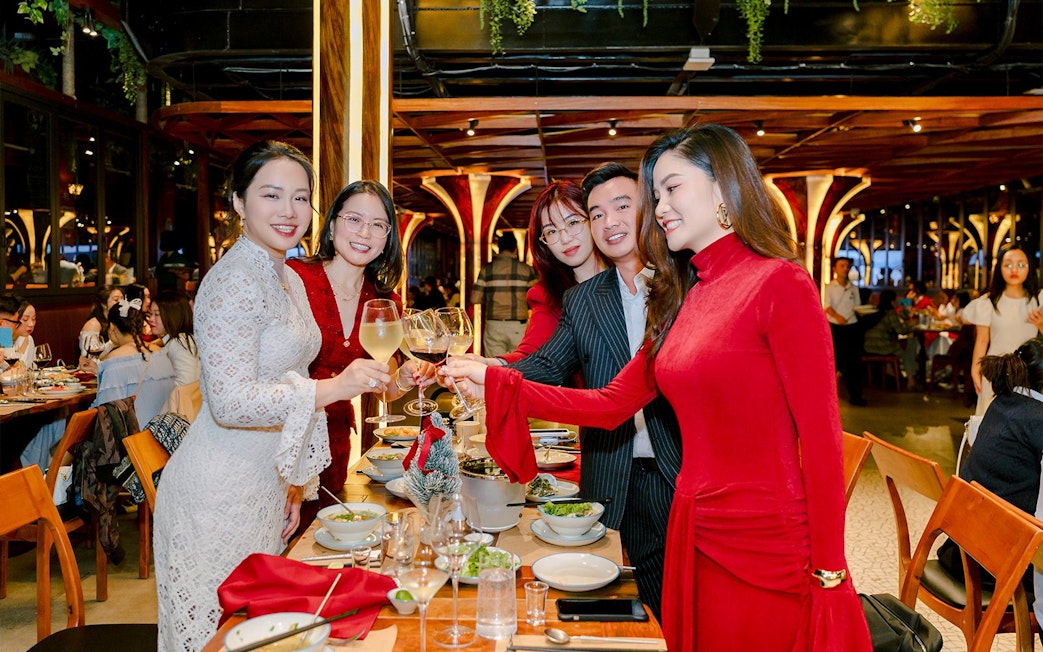 Group enjoying dinner buffet with wine at a festive restaurant setting.