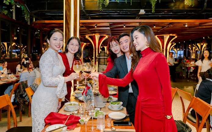 Group enjoying dinner buffet with wine at a festive restaurant setting.