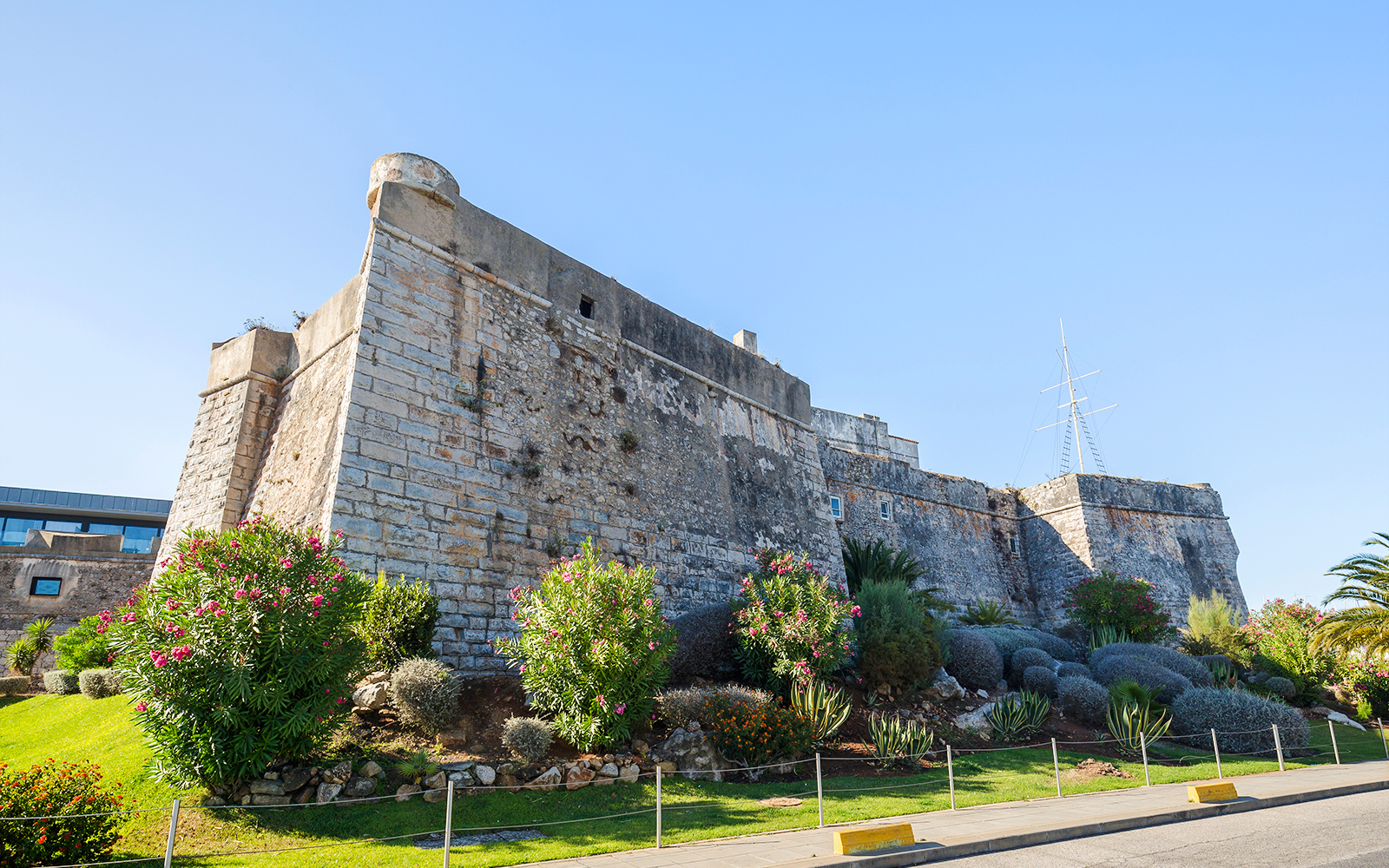 Old stone walls of the Citadel of Cascais with surrounding gardens in Cascais, Portugal.
