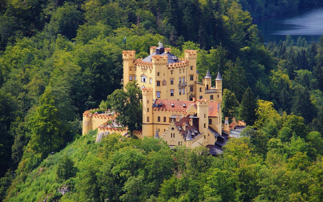 Hohenschwangau Castle surrounded by lush forest, part of the Neuschwanstein and Linderhof excursion.
