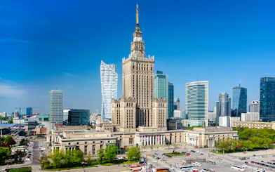 Palace of Culture and Science in Warsaw, Poland, surrounded by modern skyscrapers.