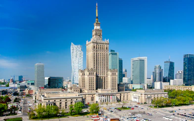 Palace of Culture and Science in Warsaw, Poland, surrounded by modern skyscrapers.