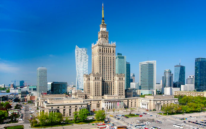 Palace of Culture and Science in Warsaw, Poland, surrounded by modern skyscrapers.