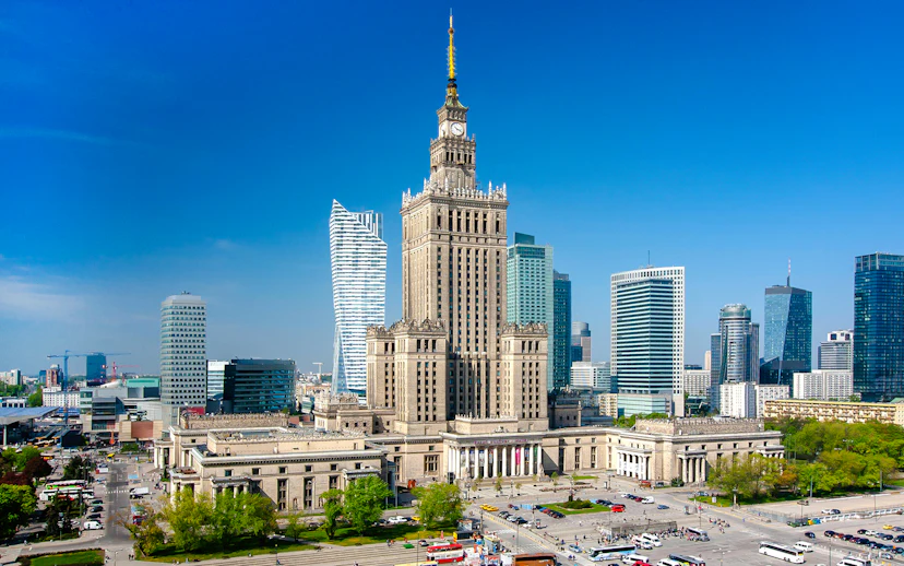 Palace of Culture and Science in Warsaw, Poland, surrounded by modern skyscrapers.