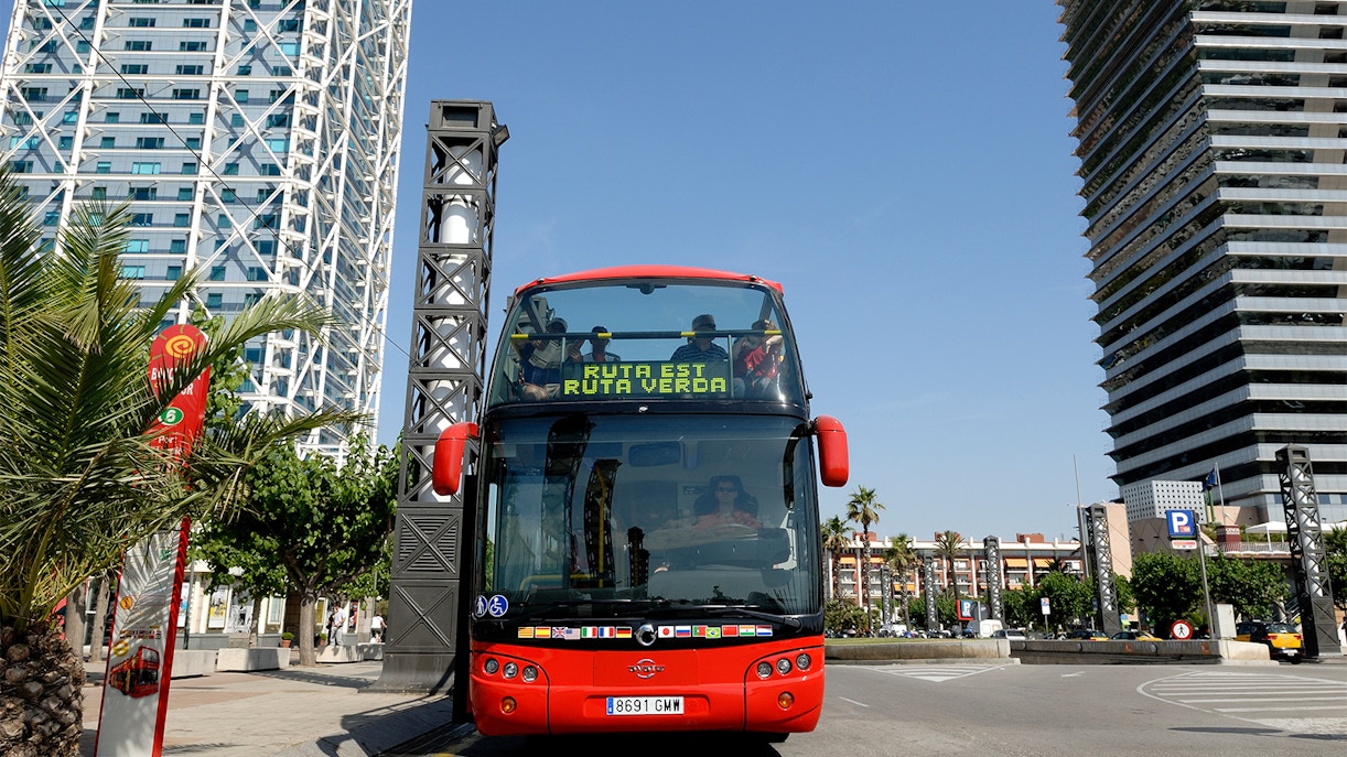 Double-decker bus on Barcelona City Hop On Hop Off Tour passing Sagrada Familia.