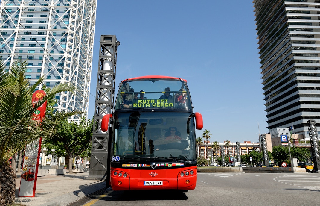Double-decker bus on Barcelona City Hop On Hop Off Tour passing Sagrada Familia.
