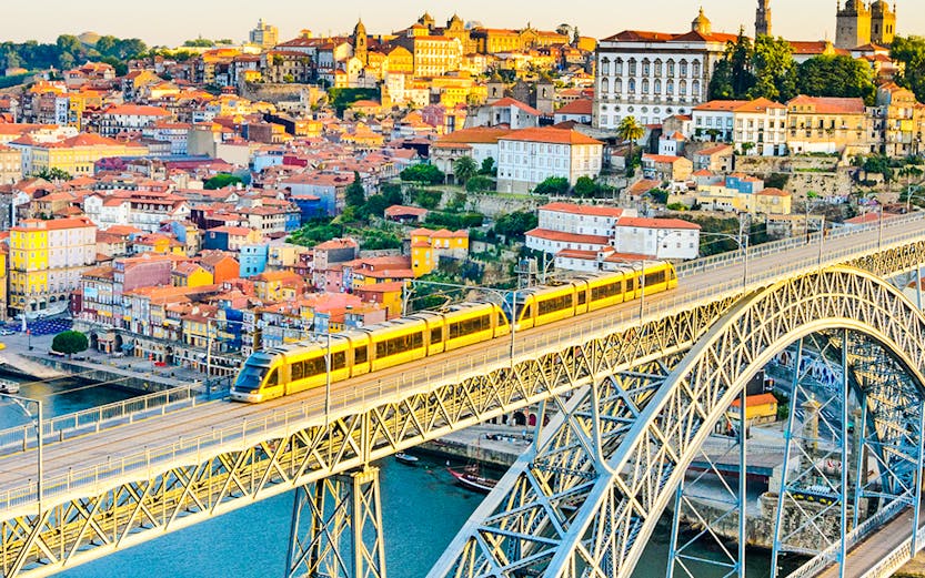 Train crossing Dom Luís I Bridge over Douro River in Porto, Portugal.
