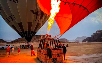 Hot air balloon being inflated at sunrise in Wadi Rum desert.