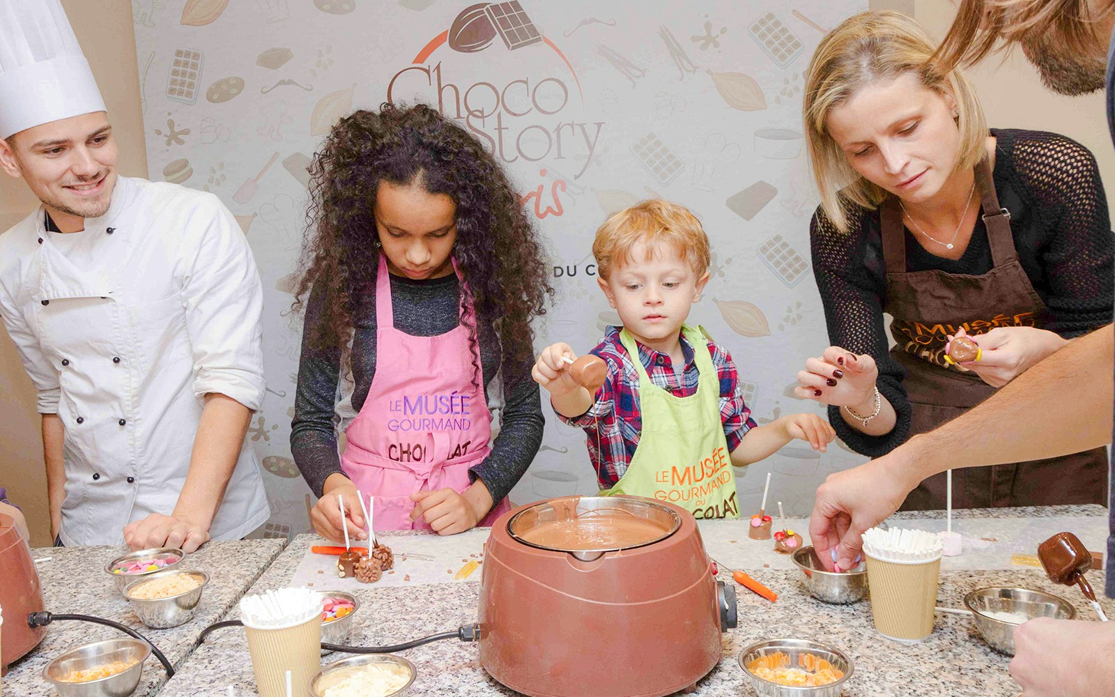 Chocolate chef guiding children in a hands-on workshop at Choco-Story Paris.