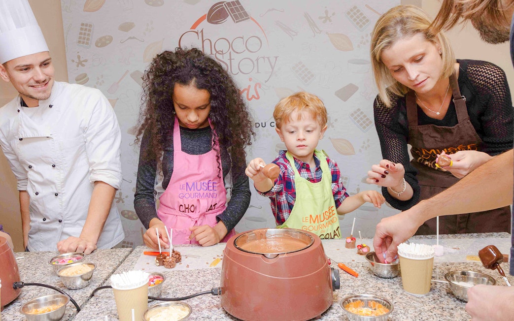 Chocolate chef guiding kids in chocolate-making at Choco-Story Paris.