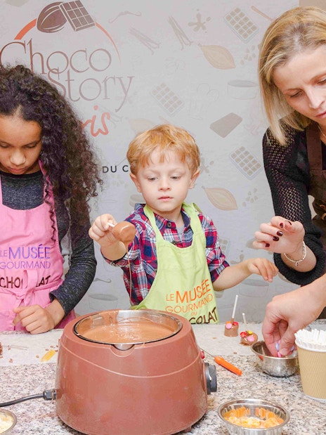 Chocolate chef guiding kids in chocolate-making at Choco-Story Paris.