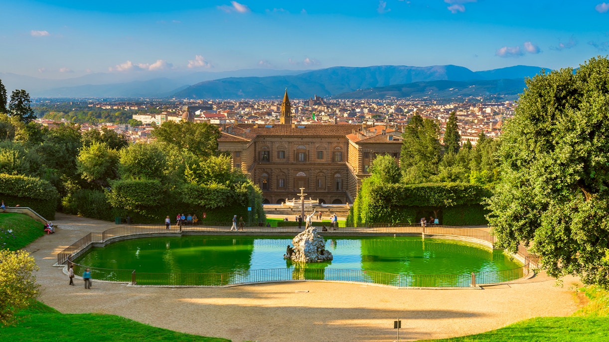 Visitors exploring the historic Boboli Gardens in Florence, Italy, with sculptures and manicured landscapes.