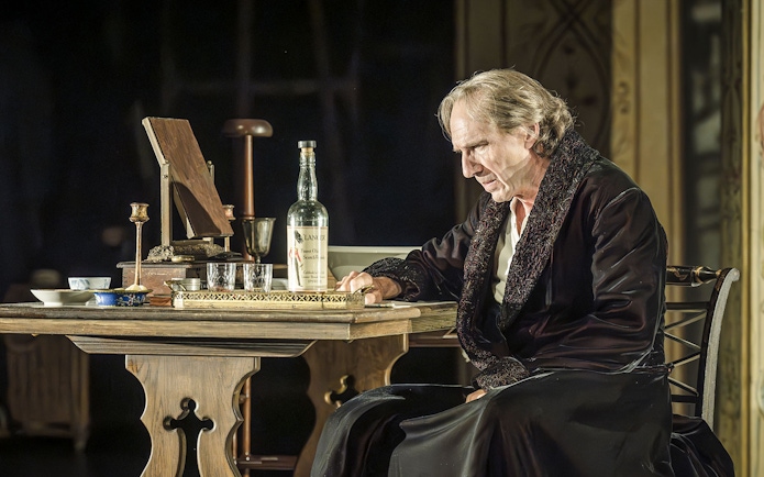 Performer seated at a table during Grace Pervades West End show.