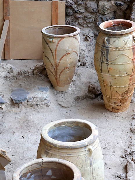 Amphorae at Akrotiri Archaeological Site, Santorini, Greece, displayed among ancient ruins.