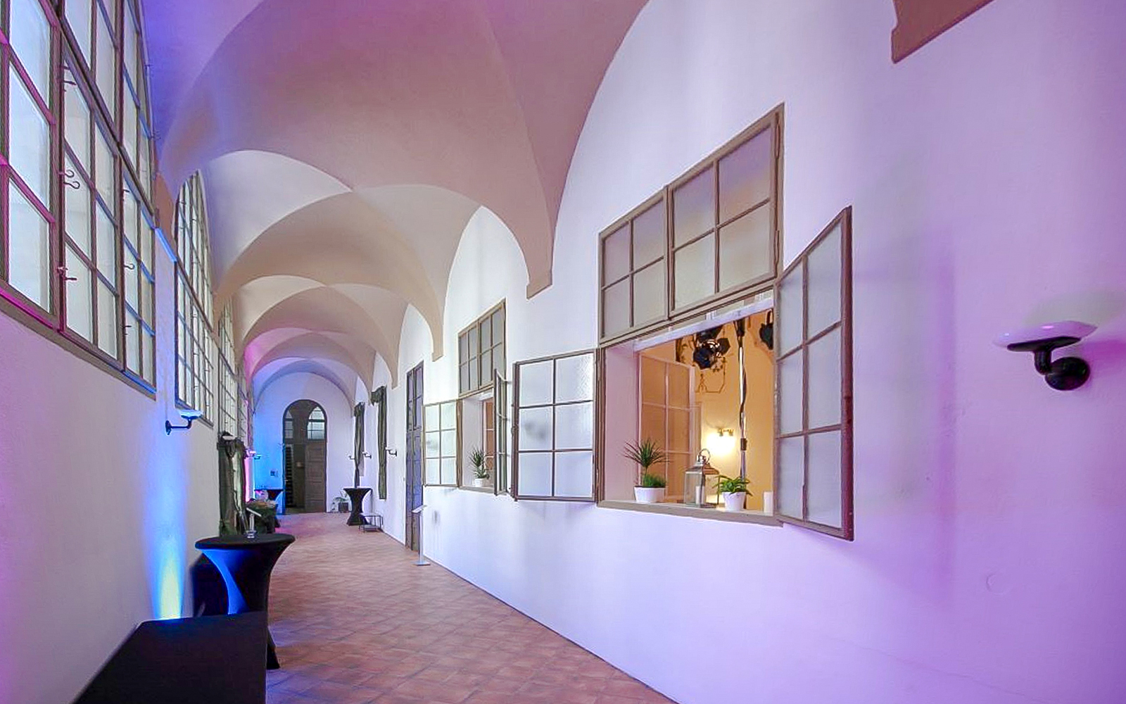 Inside corridor of Minorite Monastery of St James, Prague, with arched ceilings and open windows.