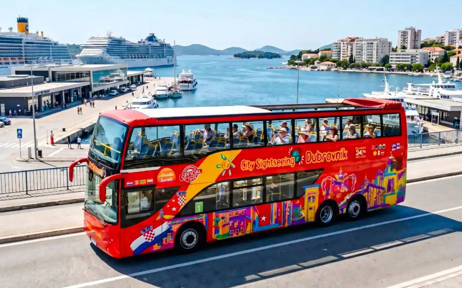 Hop on Hop Off bus near Dubrovnik port with cruise ships in the background.