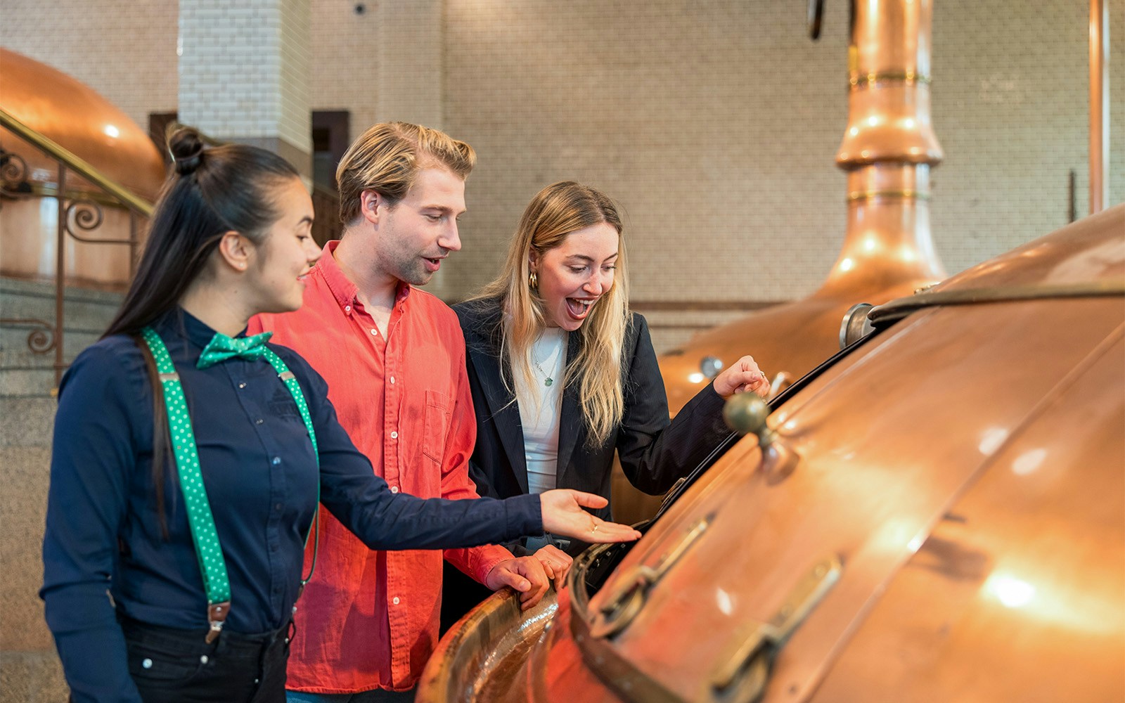 Visitors exploring brewing equipment at the Heineken Experience in Amsterdam.