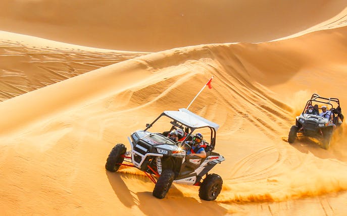 Dune buggies driving on desert sand dunes during a 20-minute safari tour.