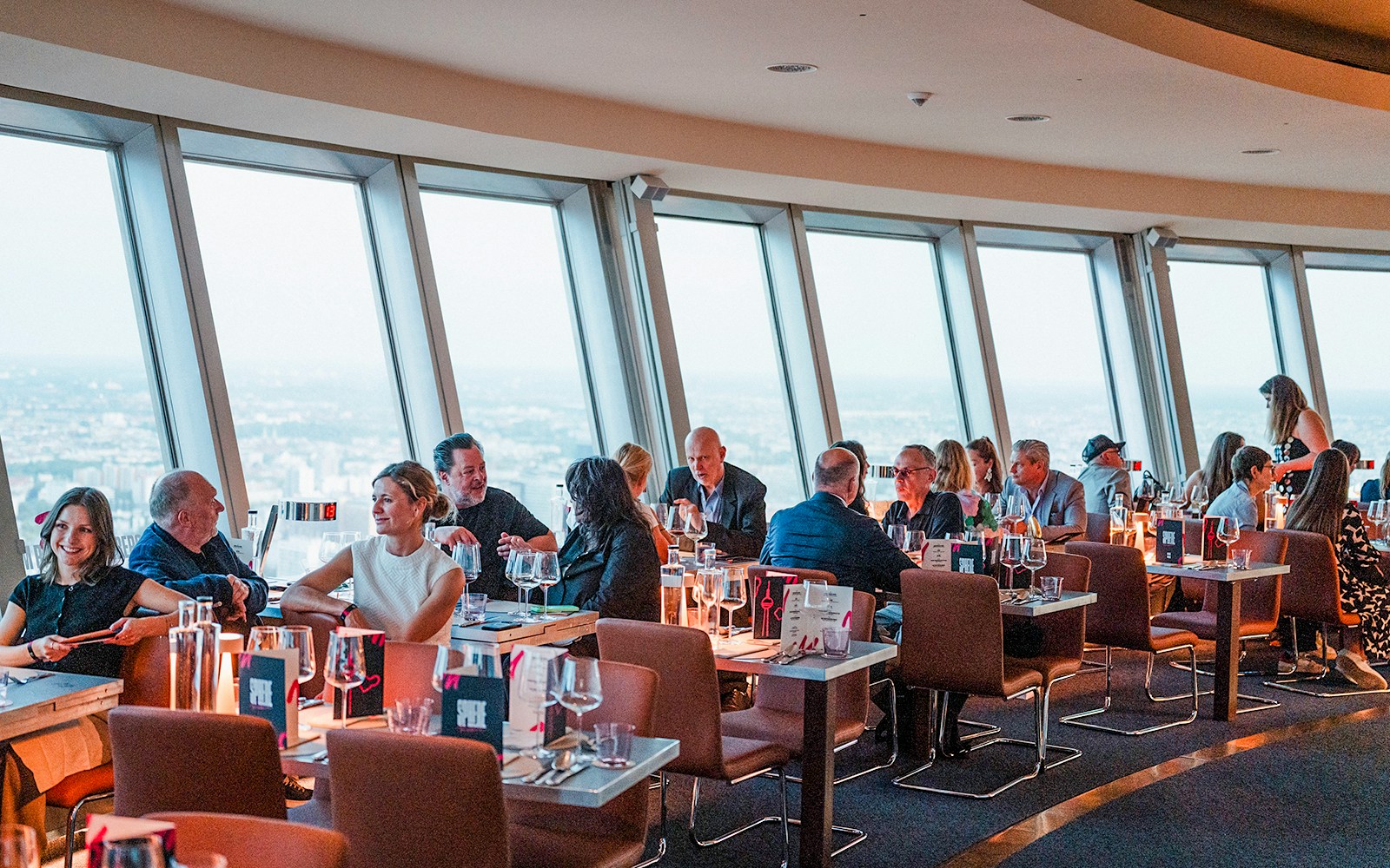 Guests dining at the Berlin TV Tower restaurant with city views.