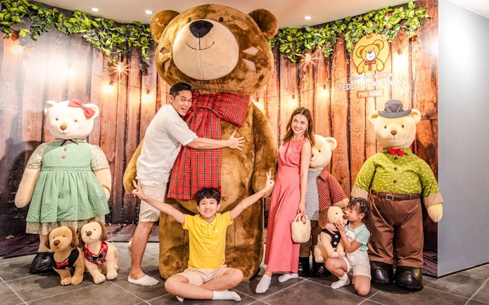 Family posing with large teddy bears at Teddy Bear Museum, Phu Quoc.