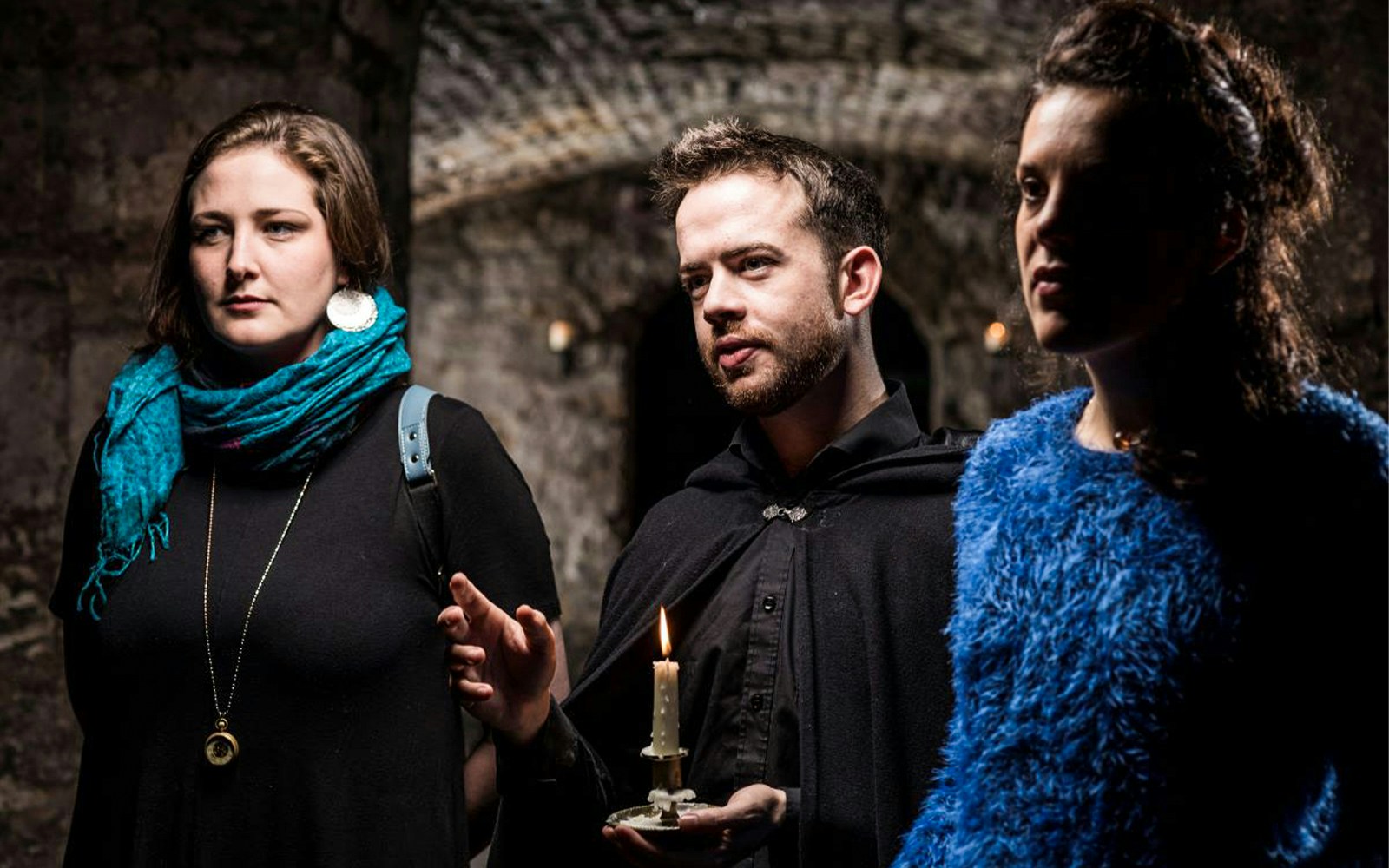 Group exploring underground passage on daytime ghost tour.