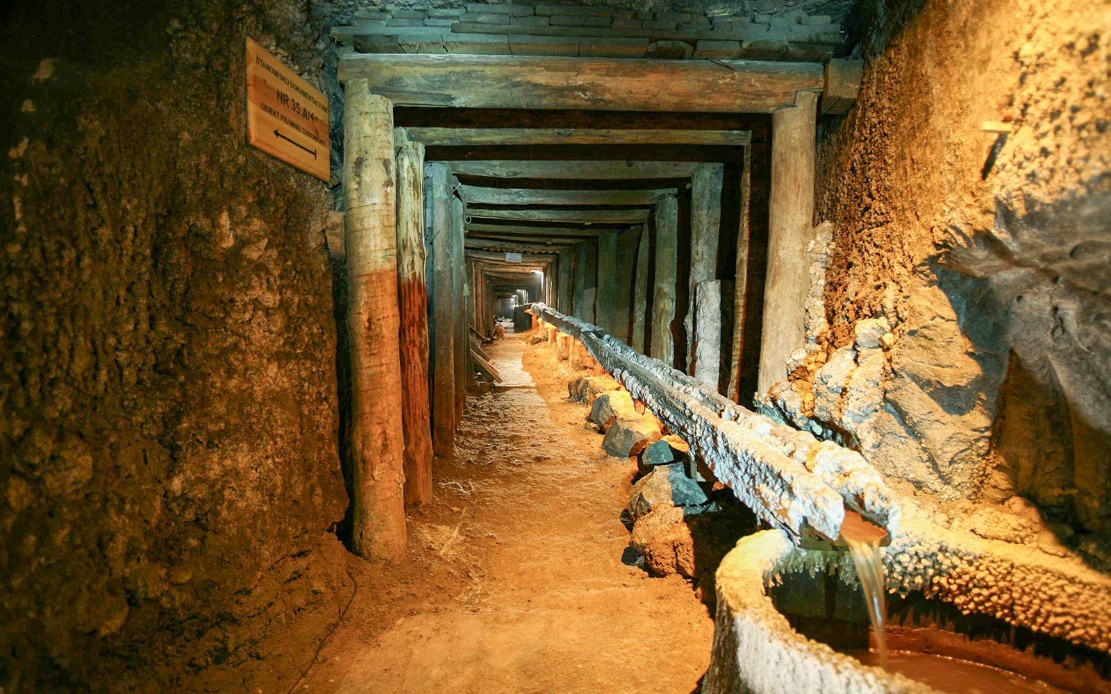 Wieliczka Salt Mine tunnel with wooden supports and brine flow, Krakow tour.