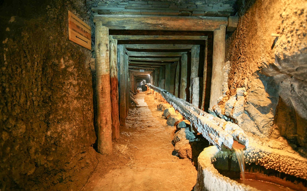 Wieliczka Salt Mine tunnel with wooden supports and brine flow, Krakow tour.