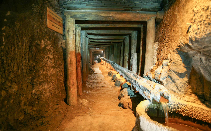 Wieliczka Salt Mine tunnel with wooden supports and brine flow, Krakow tour.