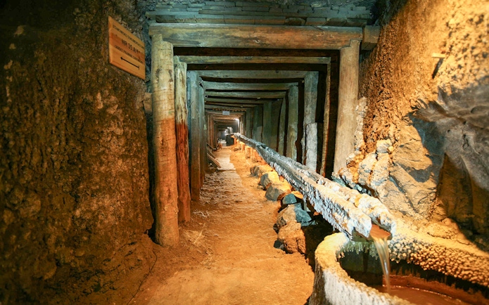 Wieliczka Salt Mine tunnel with wooden supports and brine flow, Krakow tour.