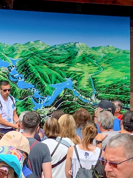 Tour guide explaining map to visitors at Plitvice Lakes, Croatia.