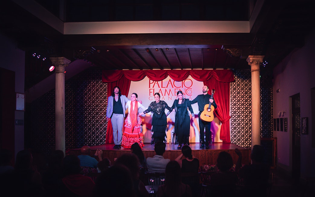 Performers on stage at Palacio Flamenco Granada show, with a guitarist and dancers.