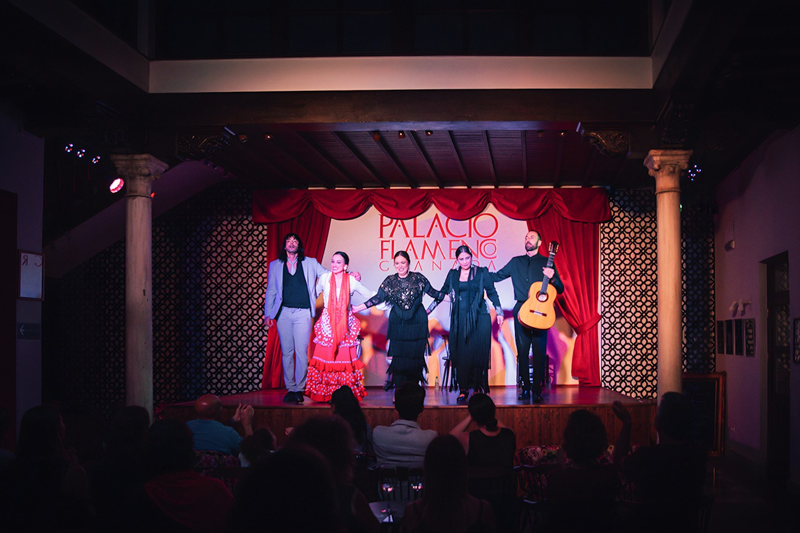 Performers on stage at Palacio Flamenco Granada show, with a guitarist and dancers.