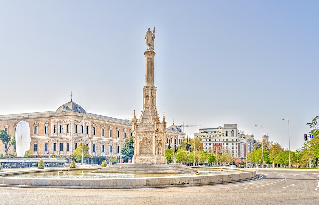Columbus Monument in Plaza de Colón, Madrid, with surrounding buildings.