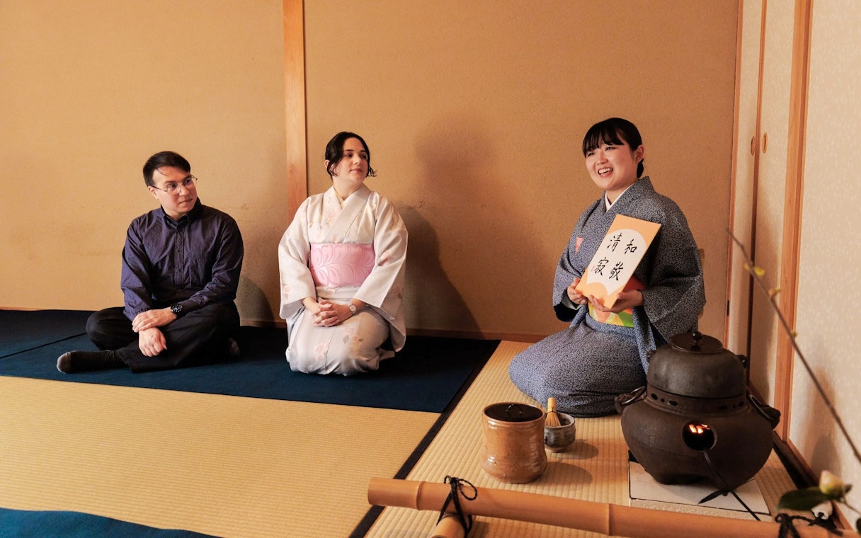 Participants in a traditional Japanese tea ceremony, seated on tatami mats.