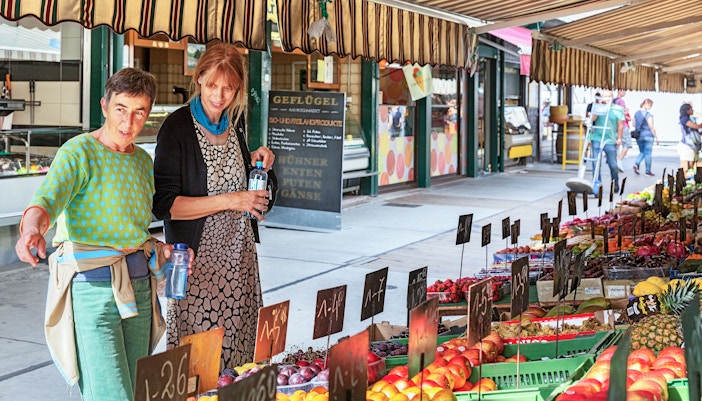 Tourist at Naschmarkt with vendor, Vienna