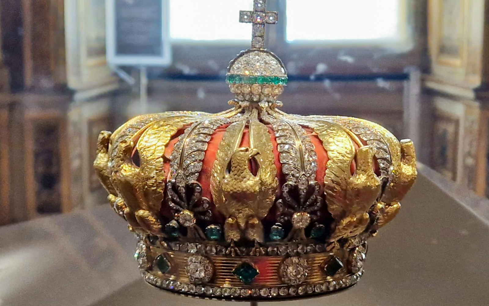 French Crown Jewels display at Louvre Museum, Paris with visitors observing the collection.