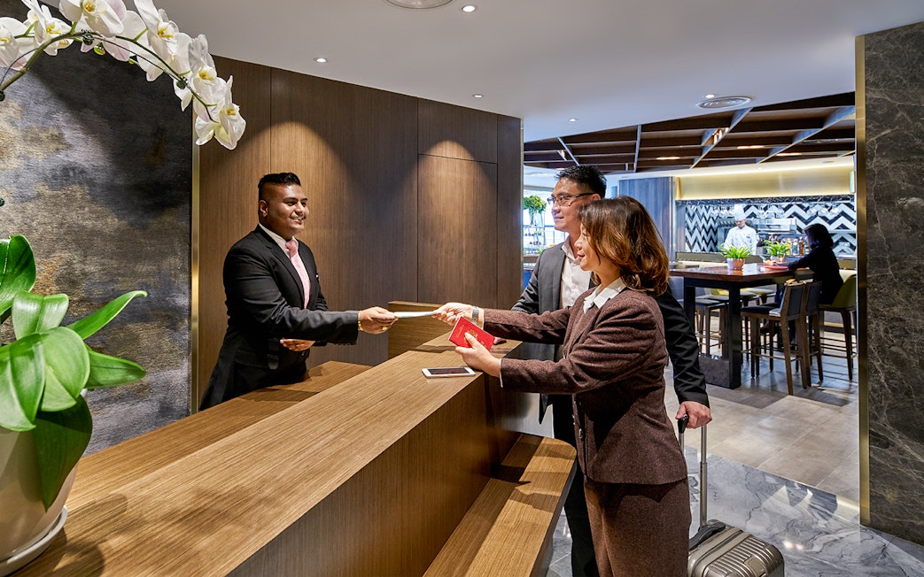 Guests checking in at Plaza Premium First Lounge, KLIA Terminal 1 reception desk.