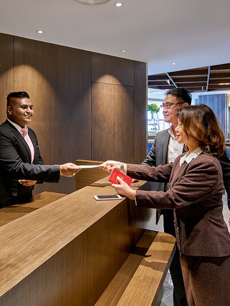 Guests checking in at Plaza Premium First Lounge, KLIA Terminal 1 reception desk.