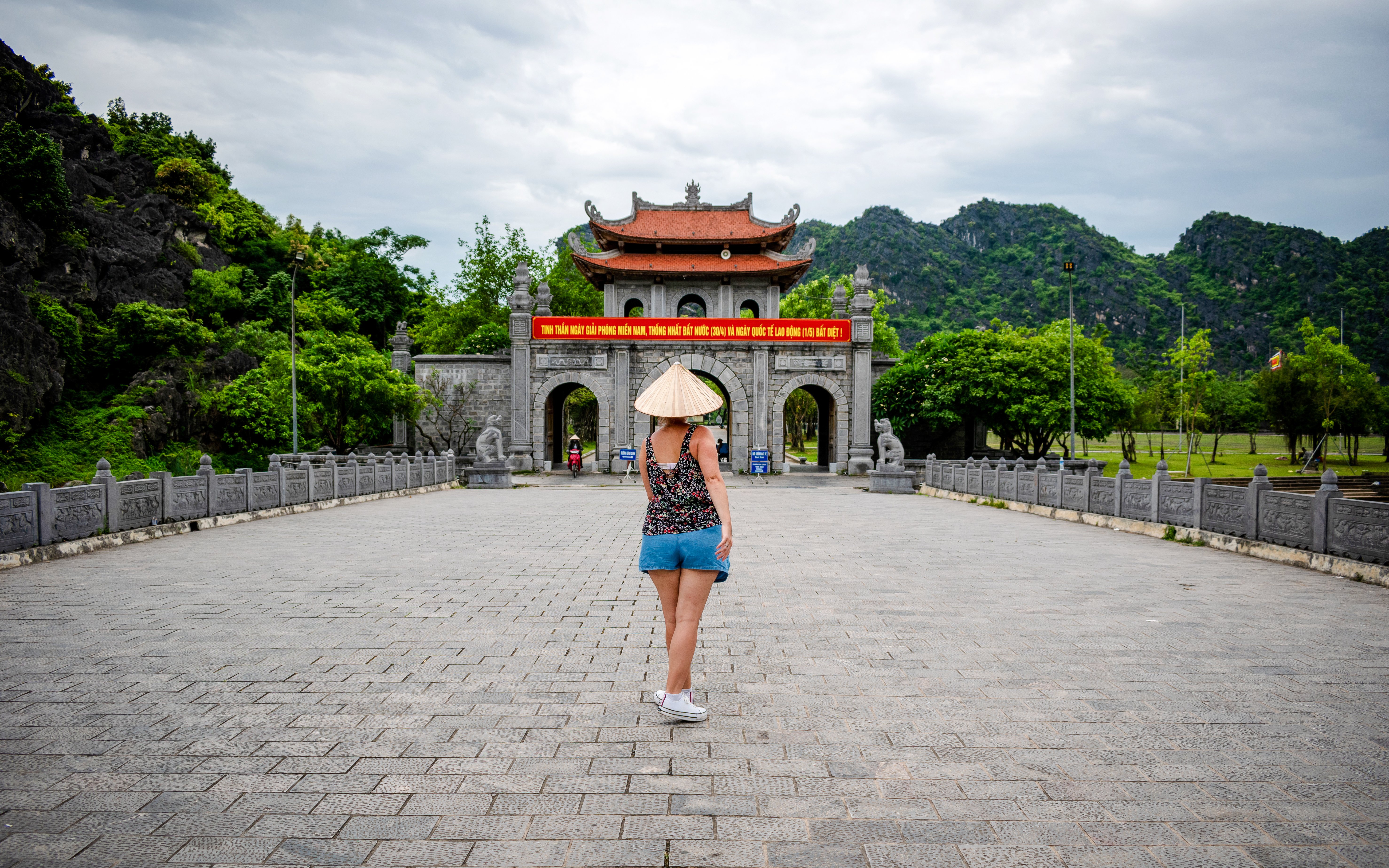 Tourist walking towards ancient gate in Hoa Lu, Vietnam.