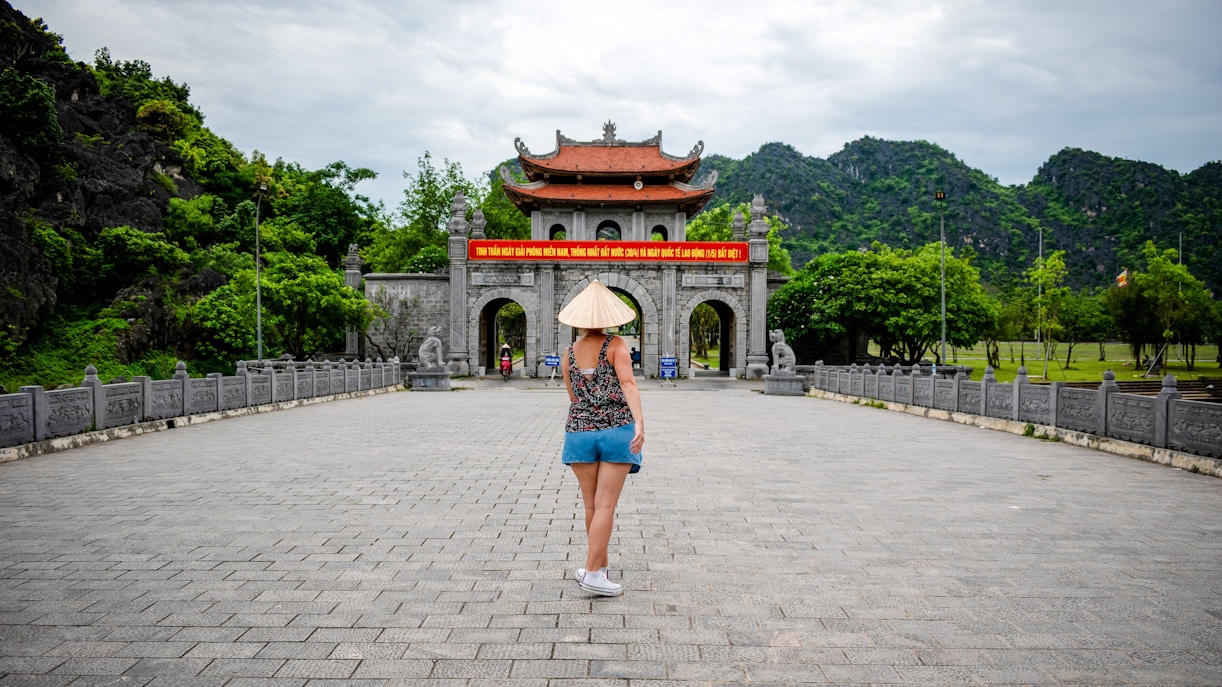 Tourist walking towards ancient gate in Hoa Lu, Vietnam.