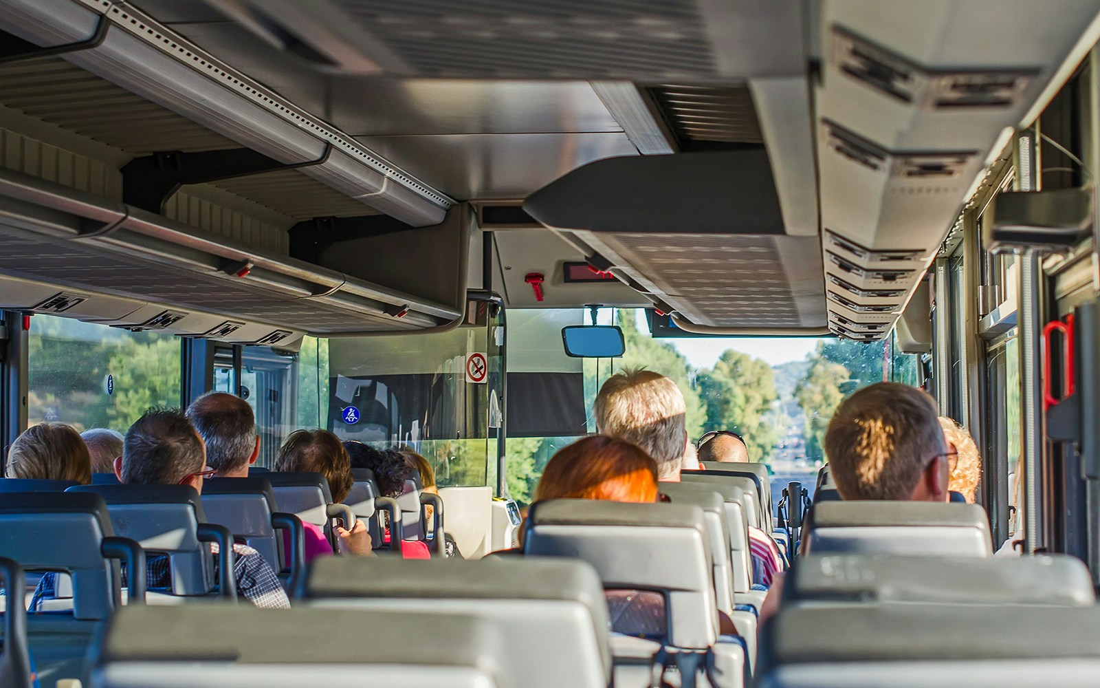 Passengers seated inside an AC bus on a one-day guided tour.