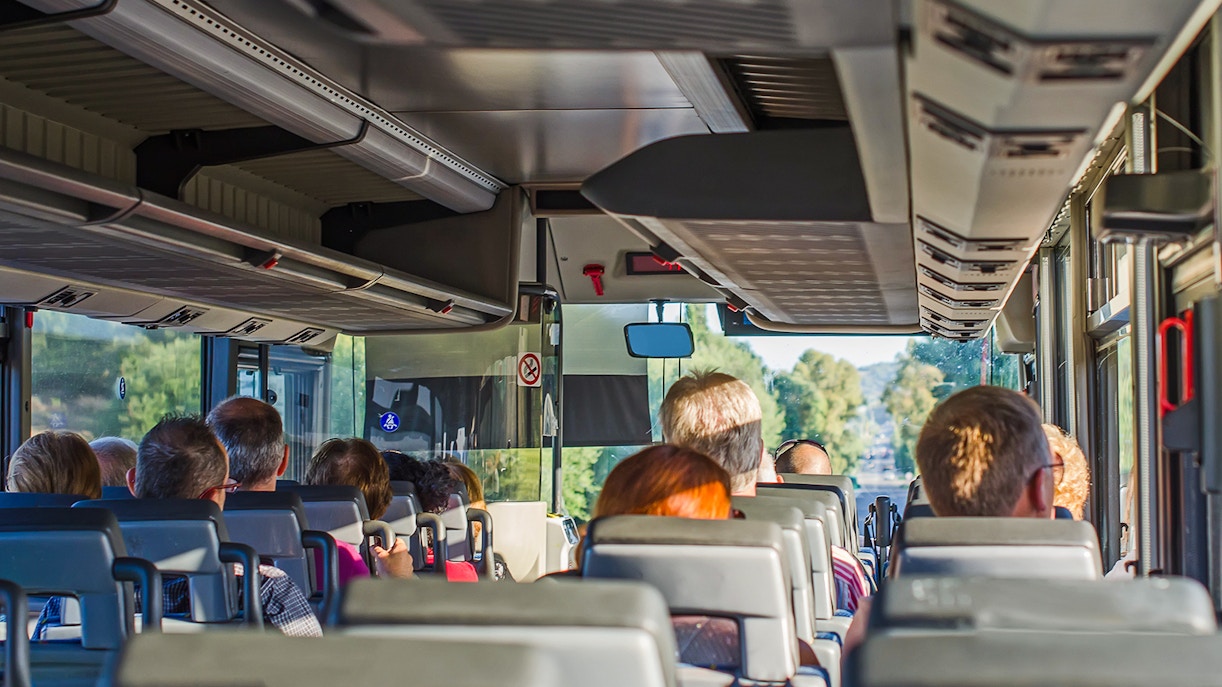 Passengers seated inside an AC bus on a one-day guided tour.