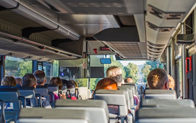 Passengers seated inside an AC bus on a one-day guided tour.