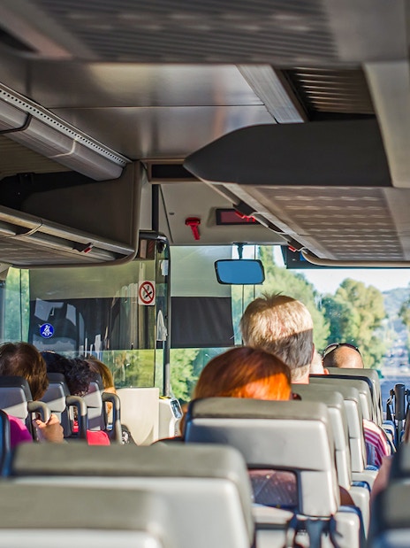 Passengers seated inside an AC bus on a one-day guided tour.