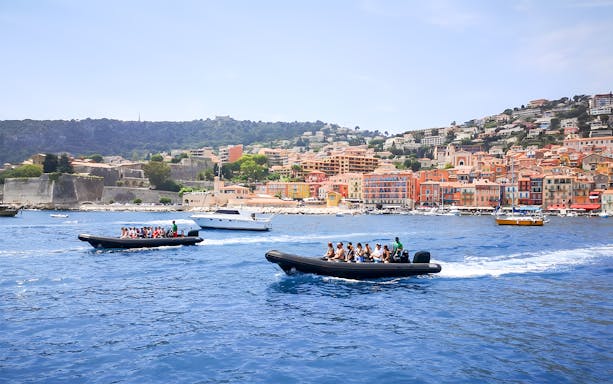 People on a boat tour near colorful buildings of St Jean Cap Ferrat.