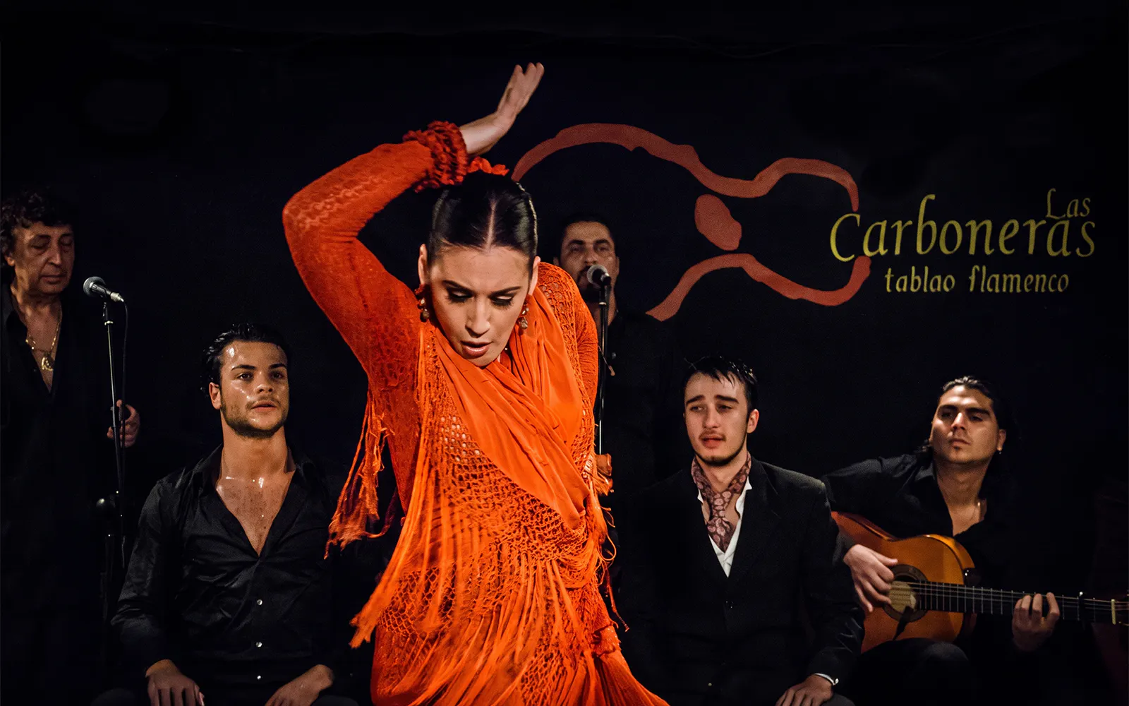 Flamenco dancer performing at Tablao LAS CARBONERAS with musicians in Madrid.