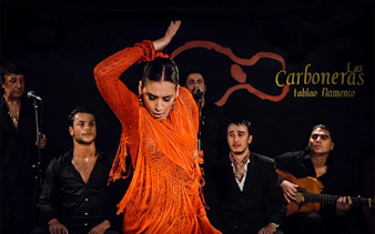 Flamenco dancer performing at Tablao LAS CARBONERAS with musicians in Madrid.
