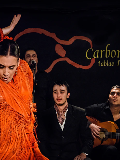Flamenco dancer performing at Tablao LAS CARBONERAS with musicians in Madrid.