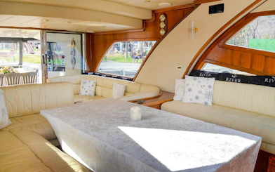 Indoor seating area on Bosphorus private luxury yacht with large windows.